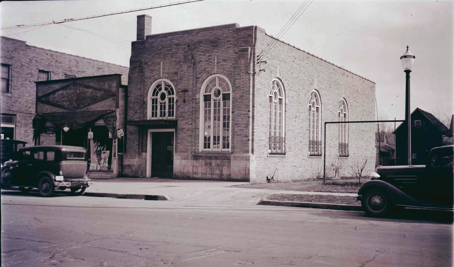 A tavern, later a pharmacy and again a tavern, at 909 W. Saginaw Ave. and the bank at 913 W. Saginaw St., as they looked in 1940. Both buildings were renovated by Aaron Williams. The former bank is a roastery for the Strange Matter Coffee and the other is up for sale.