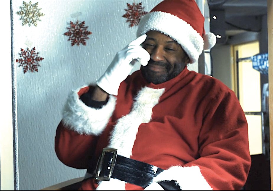 Metro Melik gives a knowing nod to a child in “Drive-Through Santa,” a short film by Render Studios. He’ll play Santa in person at the Black Santa Experience, Nov. 26 at The Venue in the Lansing Mall.