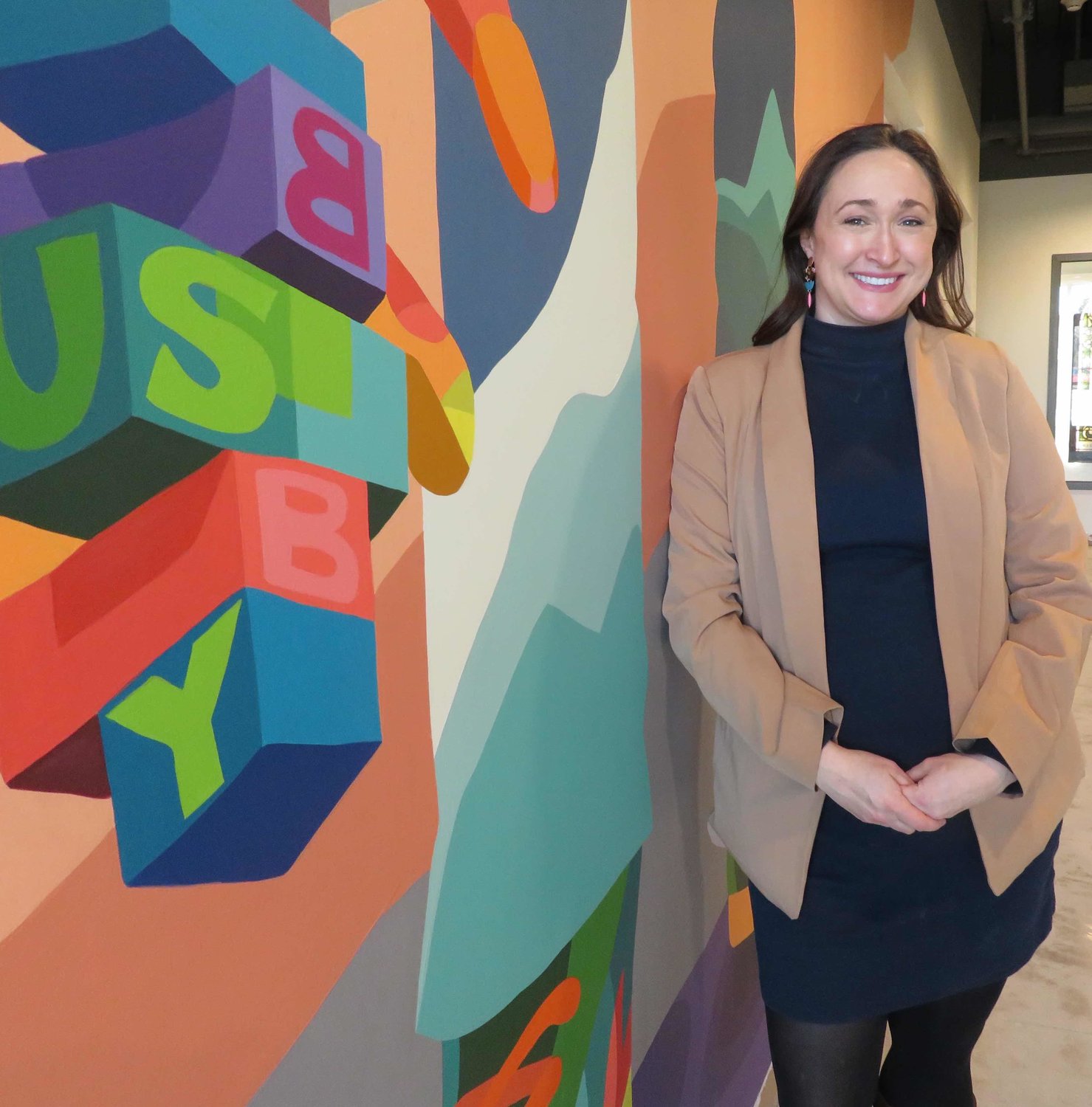 Marilyn Chrumka of Michigan Community Capital, developer of Temple Lofts, will share her non-profit’s first floor office space at the Temple Lofts with new murals and old stained glass.