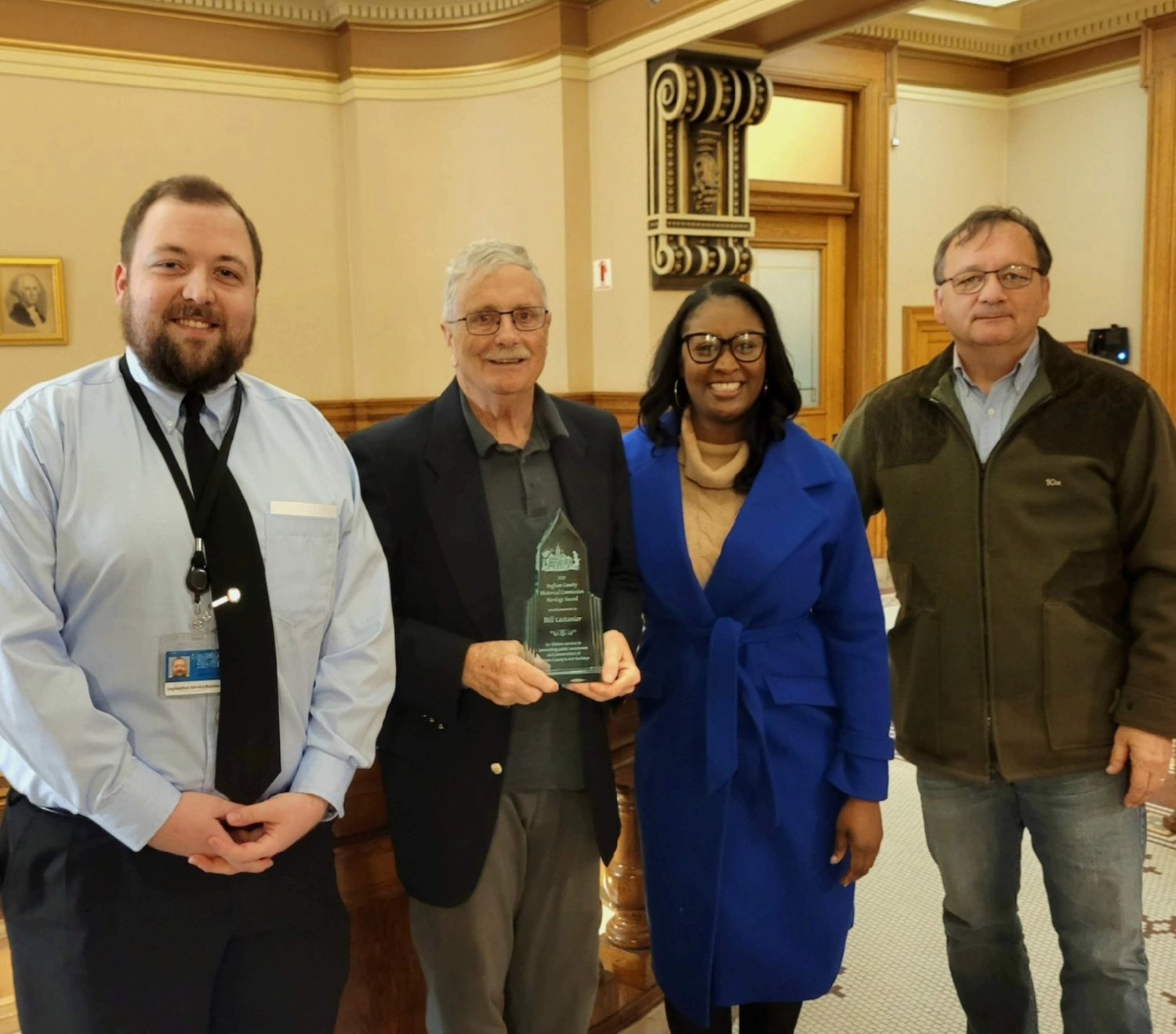 Bill Castanier, president of the Historical Society of Greater Lansing, after he received the Ingham County Heritage Award yesterday at the Ingham County Courthouse, in Mason. To his left is Jacob McCormick, who chairs the Ingham County Historical Commission and is a Historical Society trustee. State Rep. Sarah Anthony and Jesse Lasorda, a former Historical Society trustee and the commission's former vice chair, are to his right.