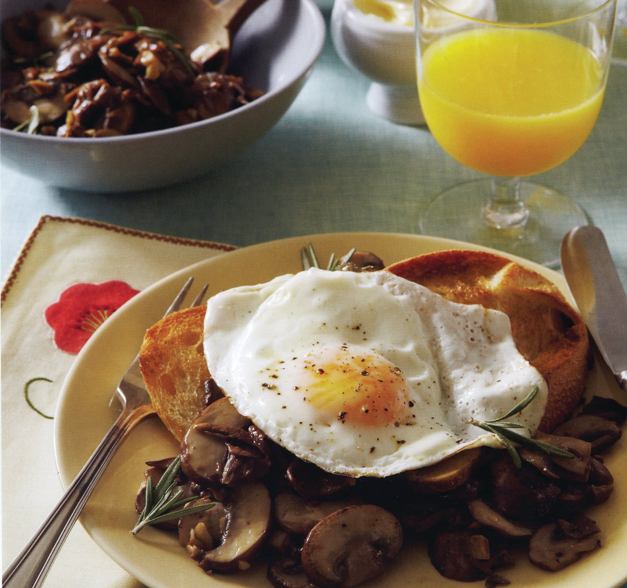 Pan-fried eggs and mixed mushroom sauté on toasted sourdough slices.