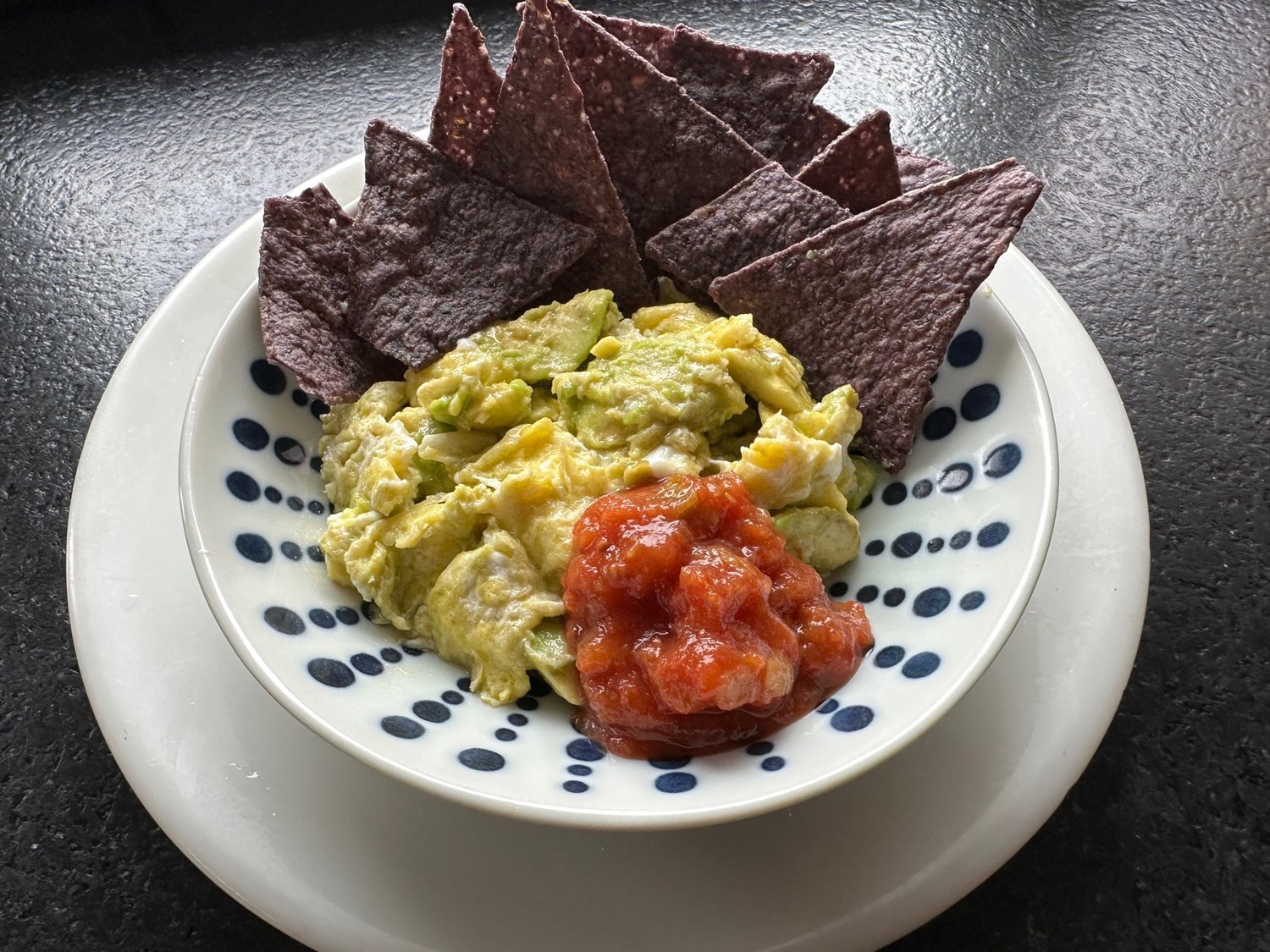 Avocado scrambled eggs, served with tortilla chips and salsa, is a unique dish to bring to Super Bowl parties.