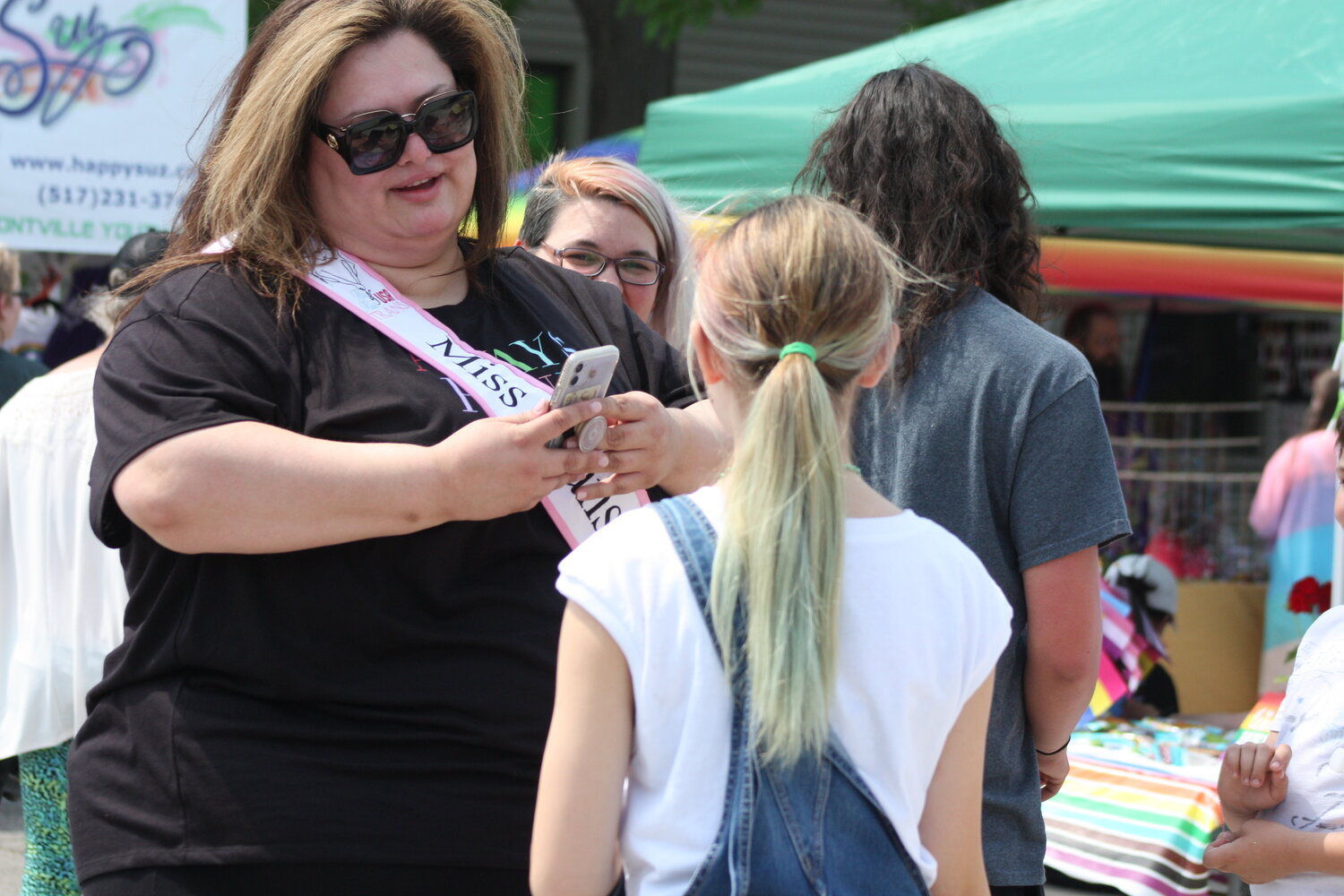 Miss Transgender Michigan Jamie Ashby greets a young admirer at St. Johns’ Pride Fest.