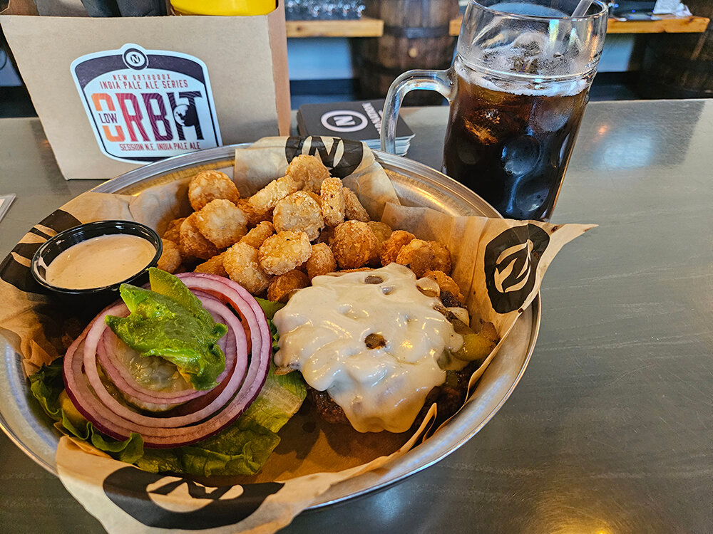 Old Nation Brewing Co.’s homemade root beer perfectly complements the topping-rich Avocado Steakhouse Burger and crispy tater-tot coins.