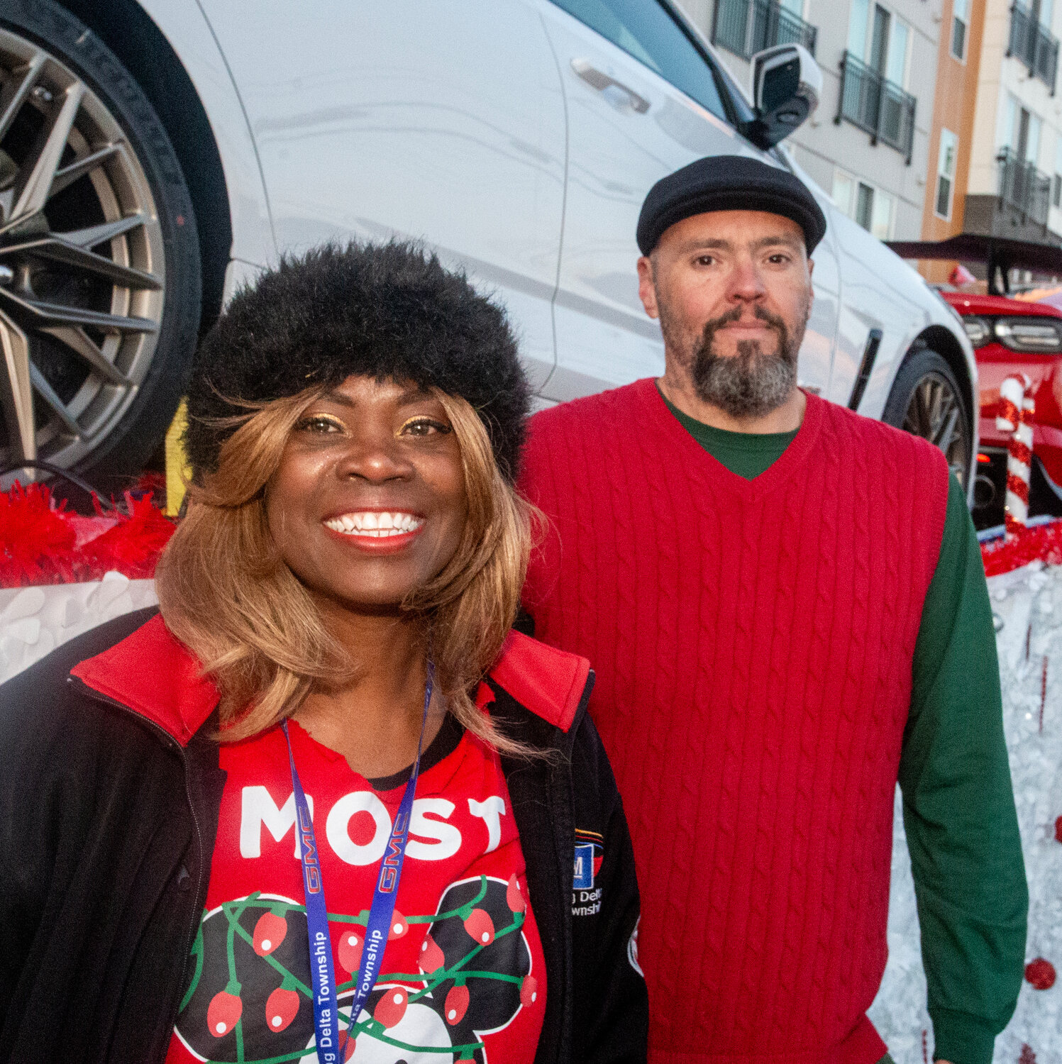 Melissa Hall (left) of General Motors and Ron Eddington of Jack Cooper, the company that hauled GM’s vehicles for the event, in front of a parade float lined with sparkly new GM cars.