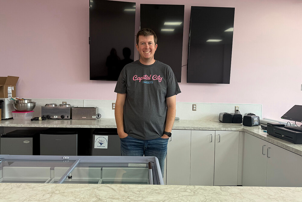Capital City Sweets co-owner Patrick Kayser stands behind the counter of the soon-to-open standalone location on Michigan Avenue.