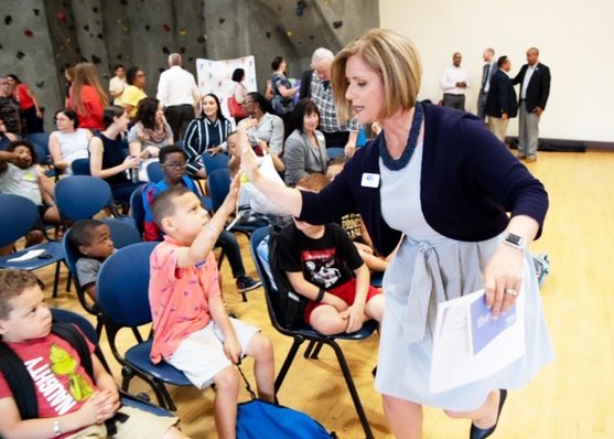 Cortney Nicolato, president and CEO of United Way of Rhode Island, high fives a member of the summer learning initiative celebration. File photo.