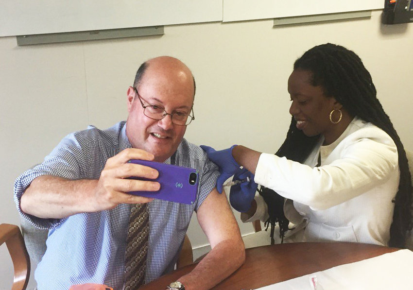 With Dr. Nicole Alexander-Scott delivering a flu shot, Steve Klamkin of WPRO pulls off the extremely rare vaccination selfie, as part of the the R.I. Department of Health&rsquo;s annual flu vaccine kickoff in 2017.