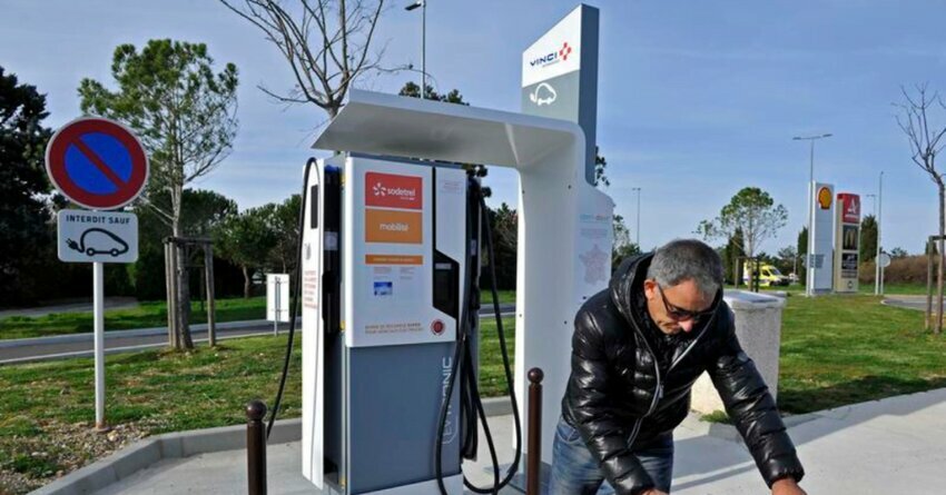 VINCI EV orange and white Charging Station. Guy charging his car. 