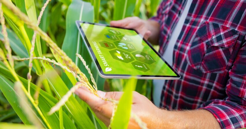 North America Leads AgroScience Market,. Man standing in a field with an ipad wearing a plaid shirt