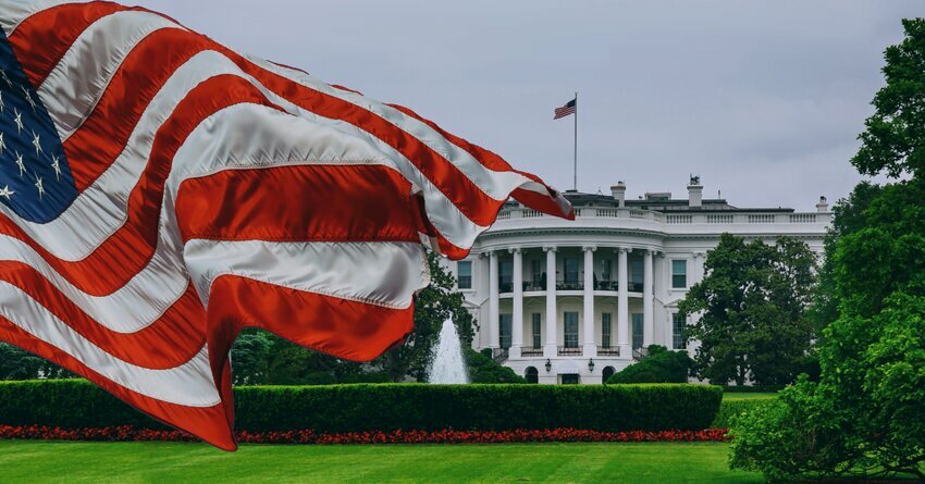 The White House is pictured with the American flag waving over half of the building.