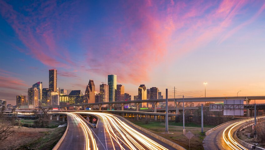 The Houston skyline contrasted against a pink and blue sky.