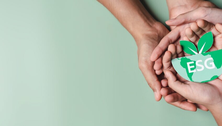 Green background with white hands holding an ESG decorative image