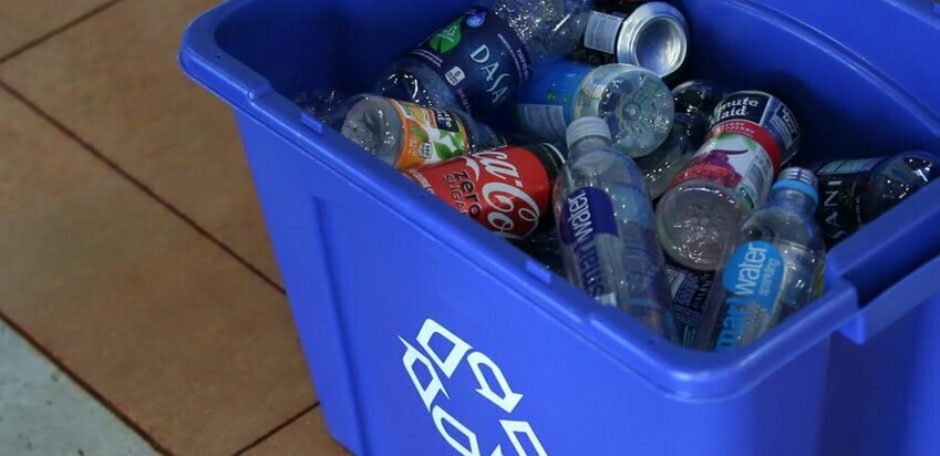 A recycling container of cans and bottles.