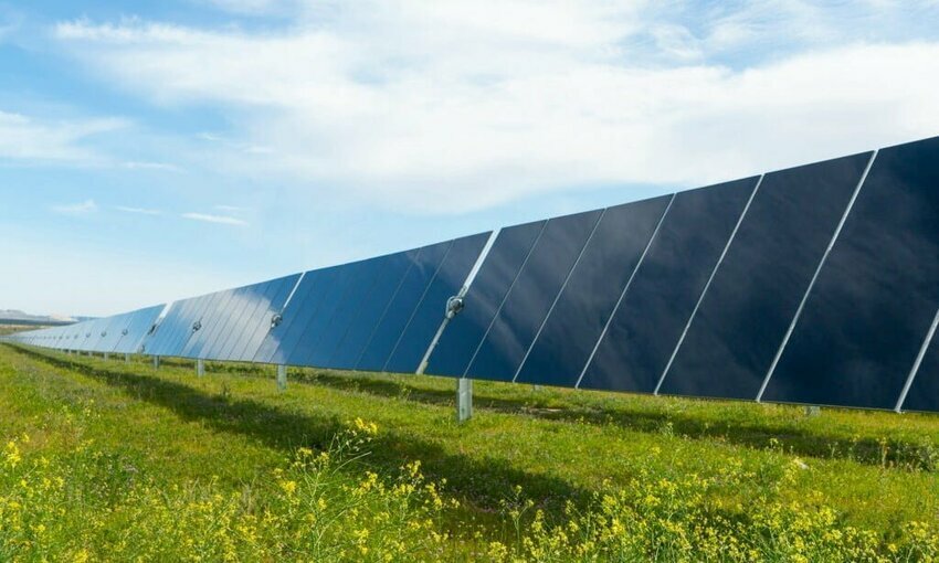 solar panels in a field with a blue sky