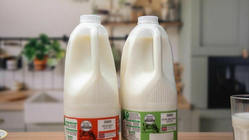 Two plastic milk bottles sit side by side filled with white milk