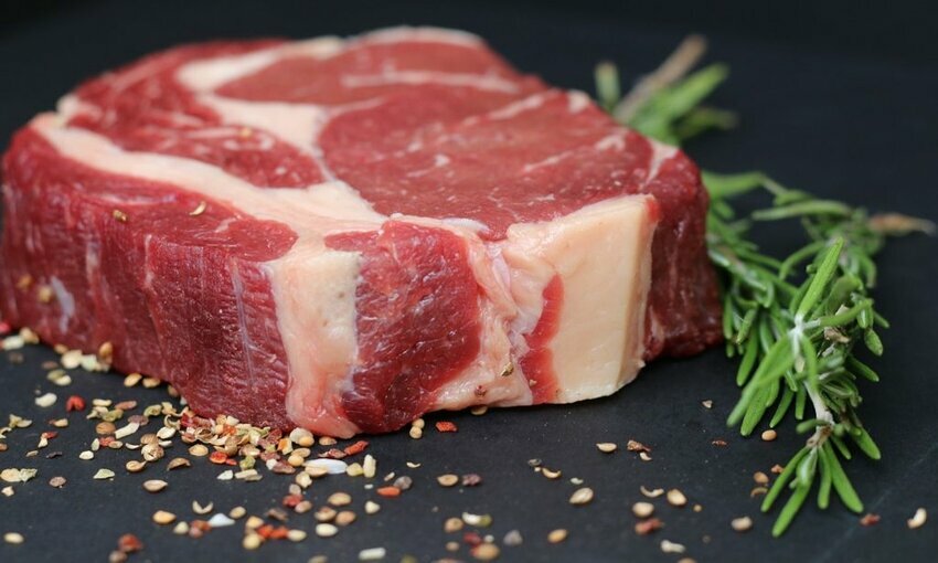 Raw steak on a table with seasoning