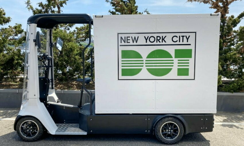 cargo bike parked on the street of New York City, reads "New York City DOT" on its side