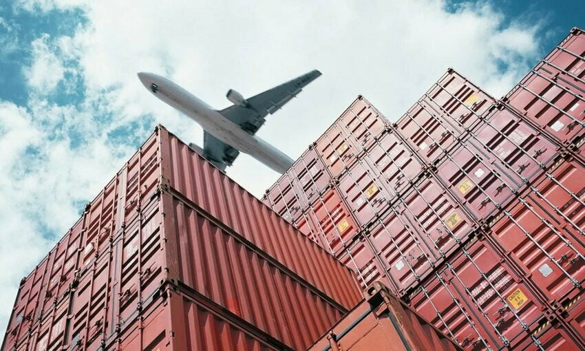 airplane flying over cargo boxes
