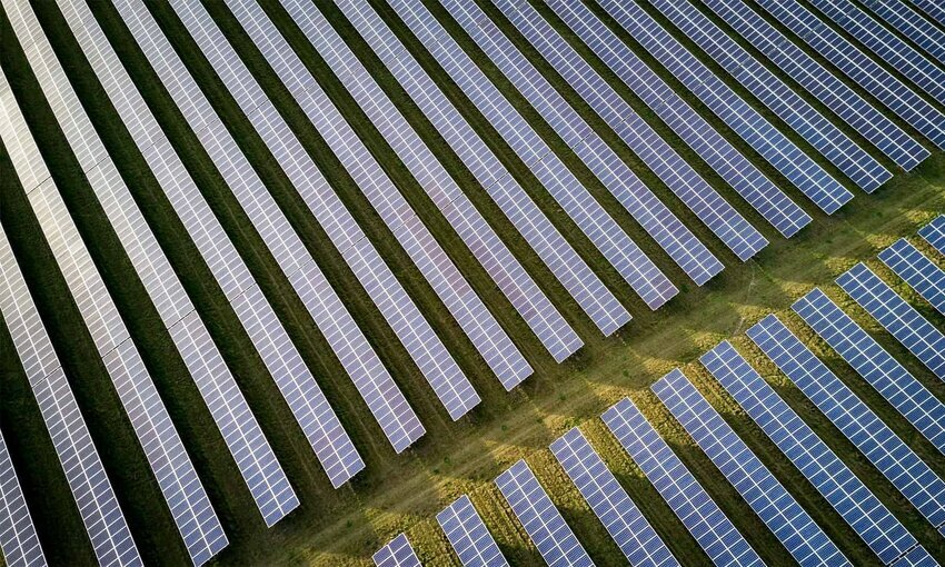 multiple rows of solar panels in a field