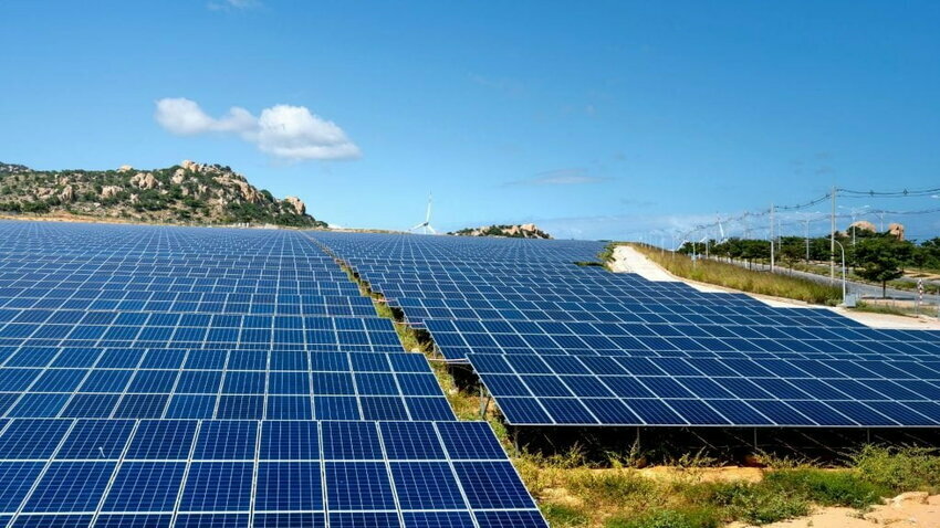 A collection of solar panels are pictured against a blue sky