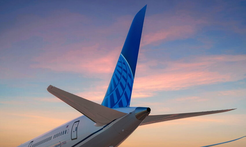 tail of a United Airlines aircraft with a sunset in the background