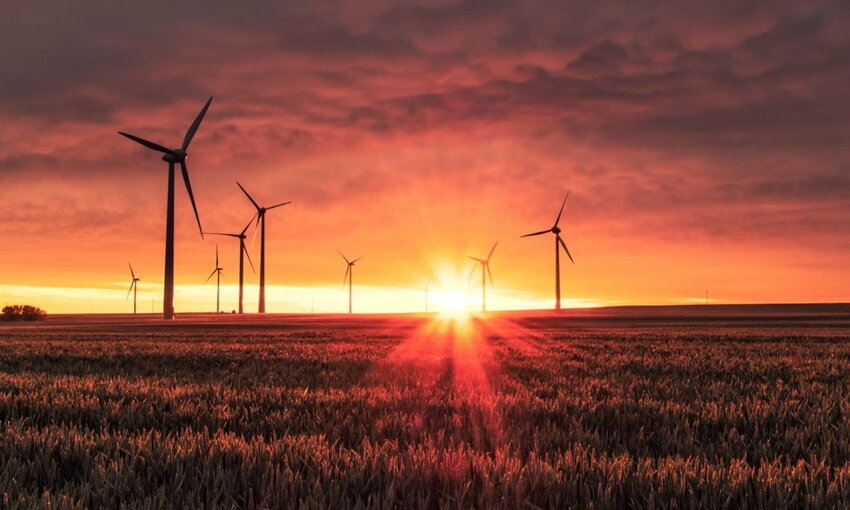 Field with wind turbines with a sunset in the background