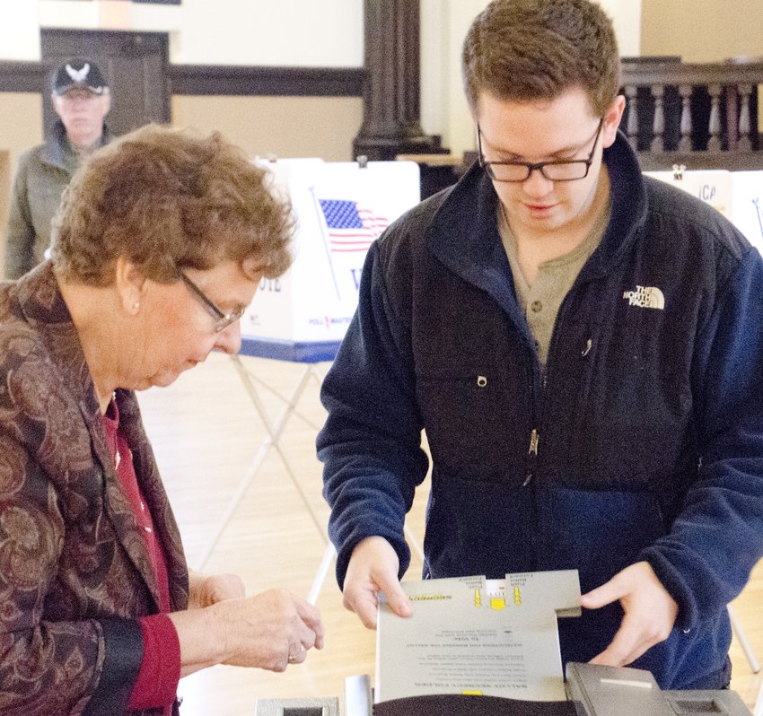 Emmett Claire submits his ballot, while election judge Helen Carroll observes, at Turner Hall on election day, Tuesday, Nov. 6.