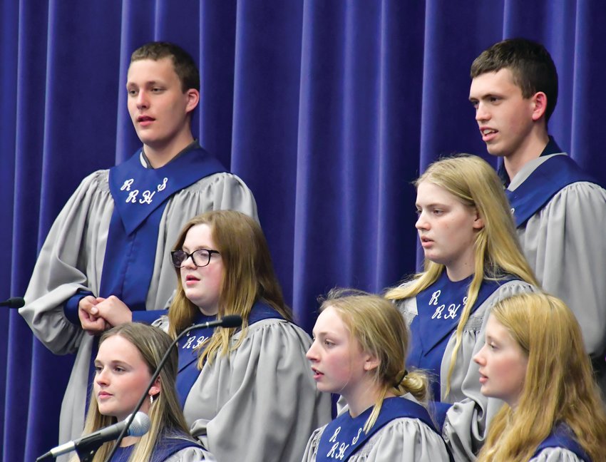 Back, from left, Nate Haas and Owen Holcomb; middle row, Sydney Benson and Avri Miller; and front, Graci Vanderheyden, Laiken Haas and Avery Engle sing &ldquo;J&rsquo;etends le moulin&rdquo; during the concert Monday, April 25. Both bands and choirs are directed by Thomas Taylor.