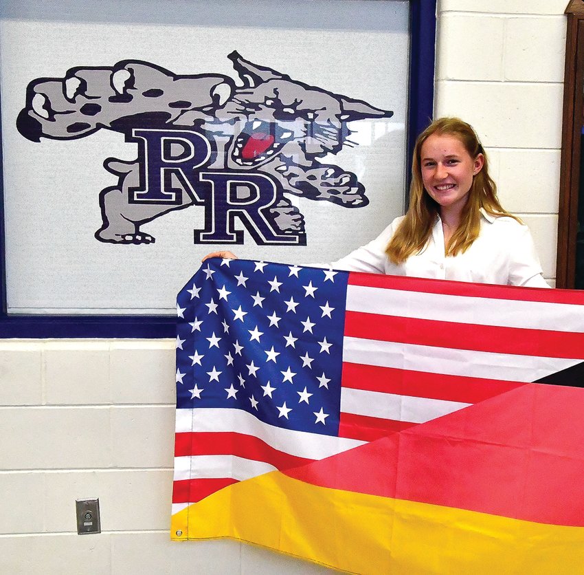 Marlene Weidner stands with a flag that she will have her classmates sign as a memento to bring back home to Germany. Weidner spent the 2021-2022 school year as an exchange student at River Ridge High School.