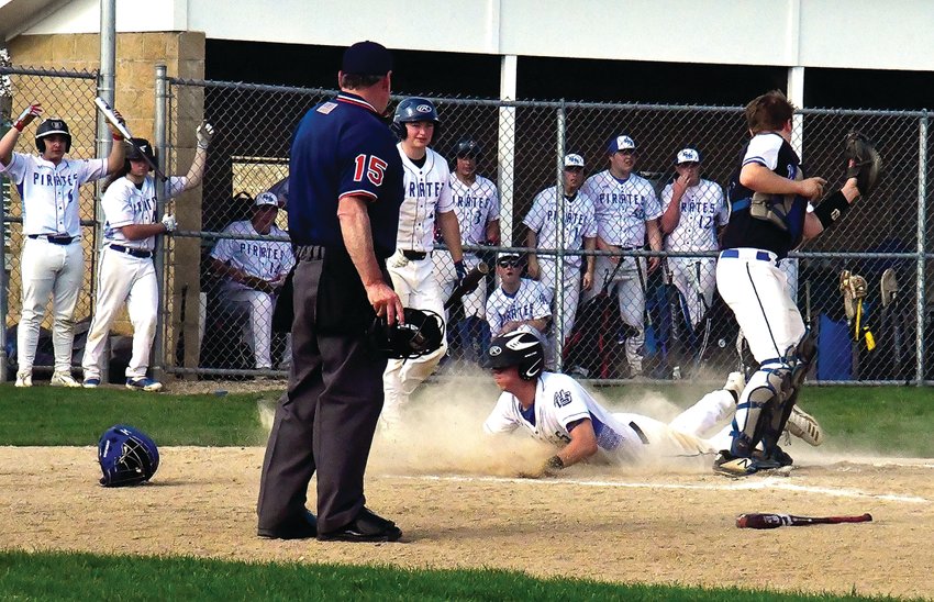 Galena&rsquo;s Parker Studtmann slides into home in the third inning behind East Dubuque catcher Colin Sutter during the Pirates&rsquo; 5-2 win over the Warriors on May 9.