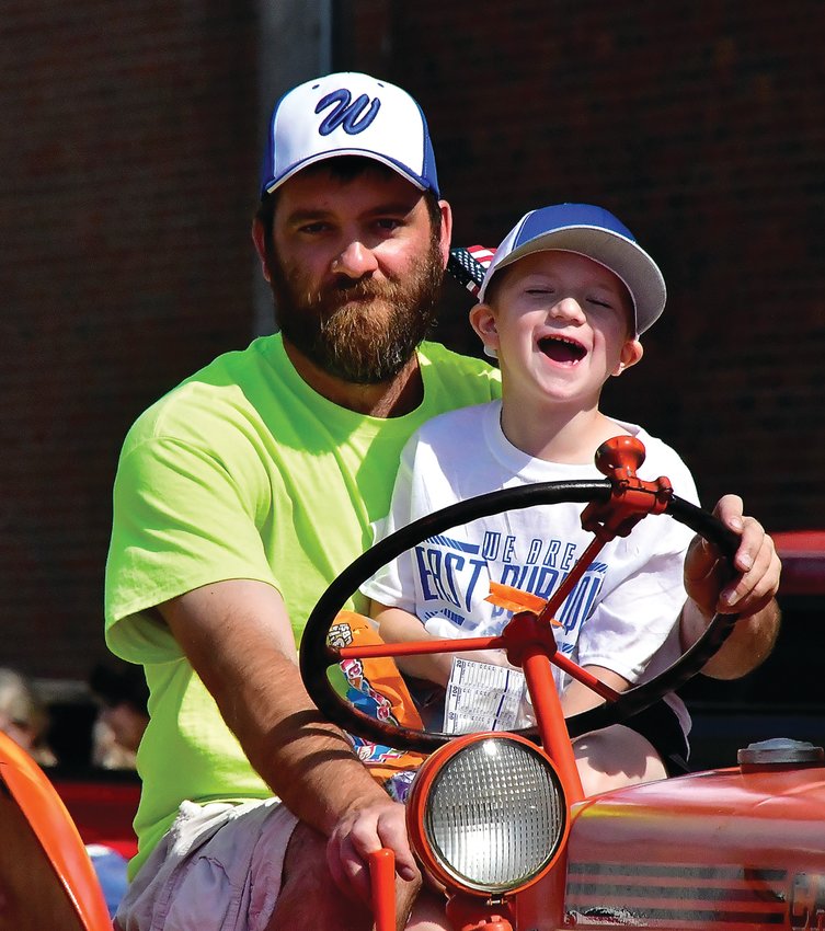 Nathan Lange and son, Gavin, ride on a tractor during the East Dubuque Memorial Day Parade on Monday, May 30. Crowds lined the street to watch the festivities and honor those who have fallen.