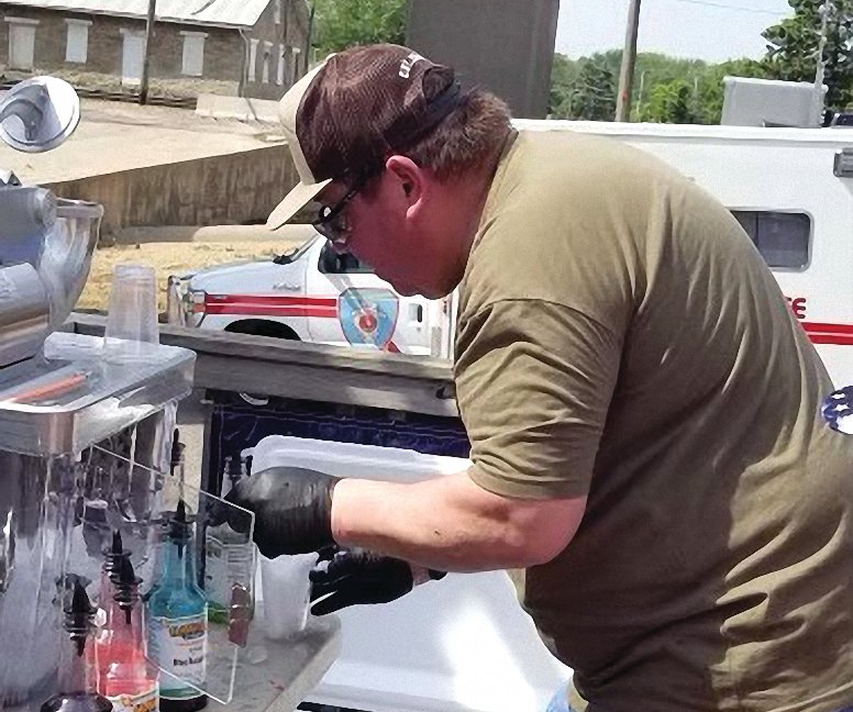 Brad Metcalf serves up shaved ice at the East Dubuque Memorial Day Parade at R Place. R Place gave free shaved ice, hot dogs and cotton candy to those in attendance. This is an annual event for R Place.
