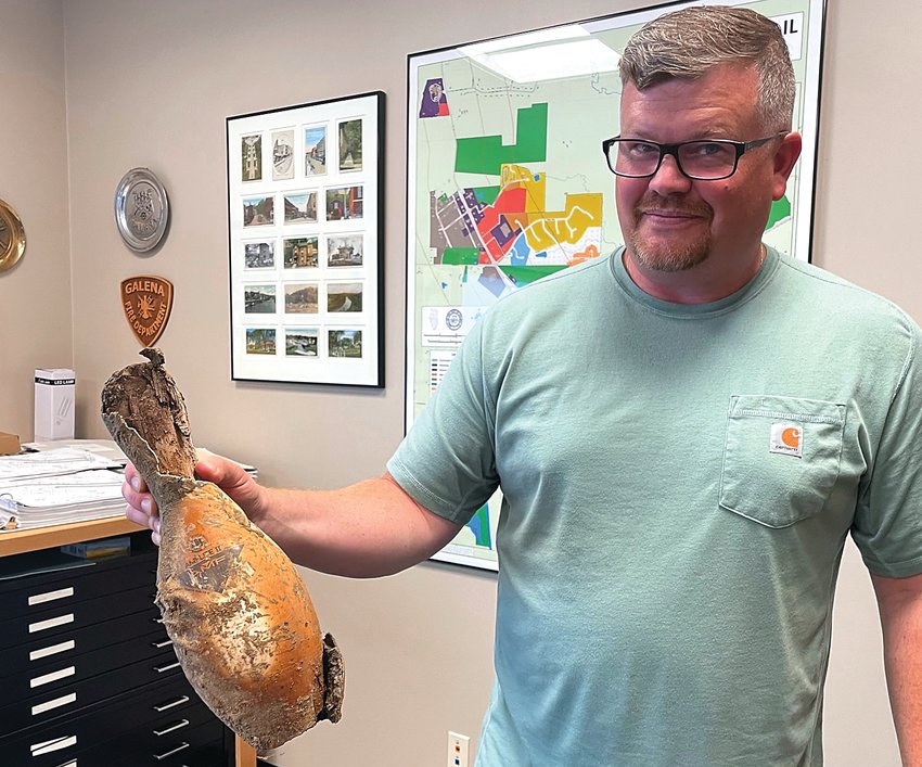 Matt Oldenburg, Galena city engineer, holds a bowling pin from Leisure Lanes that was discovered while crews were digging to repair a water main break on Galena Square Drive recently. The pin still has marks from the fire that destroyed the building nearly four decades ago.