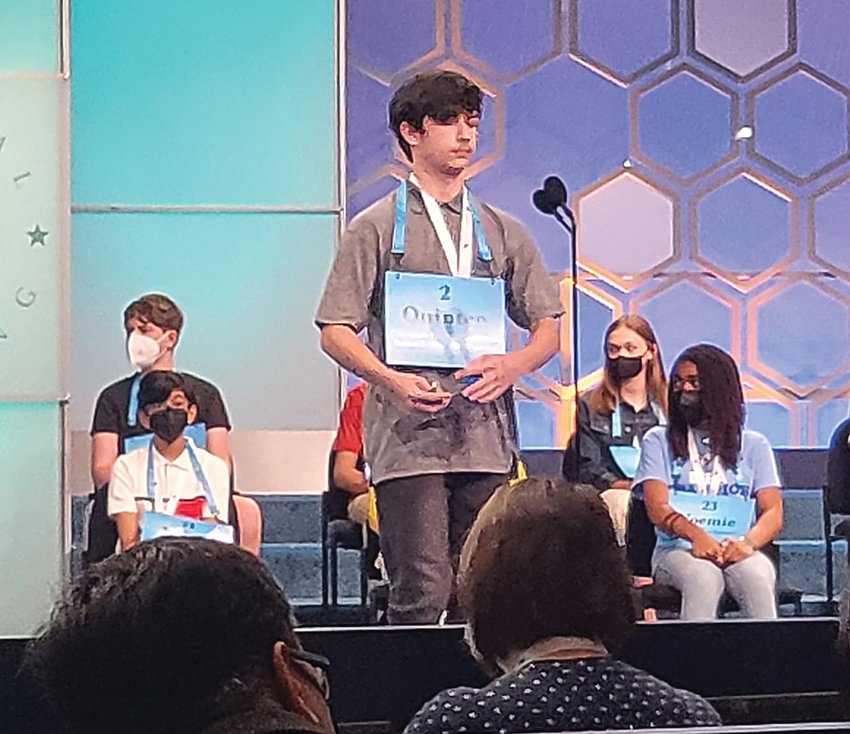 River Ridge eighth grader Quinten Atutis spells on the Scripps National Spelling Bee stage. Atutis qualified after winning the River Ridge bee and the Regional Office of Education regional bee.