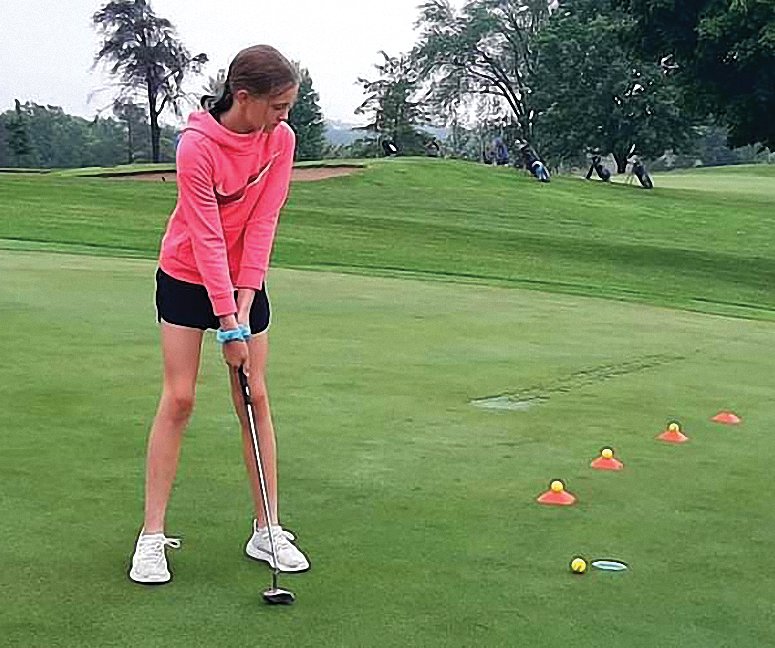 Layla DeLoach lines up a putt at junior golf camp at the Galena Golf Club on Tuesday, June 14. Nearly 130 students from kindergarten through eighth grade took part in the multi-day camp.