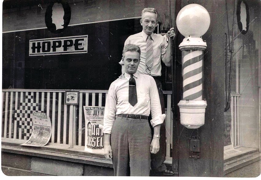 Everett Rodda and Clyde Gray stand next to a barber pole on North Main Street.