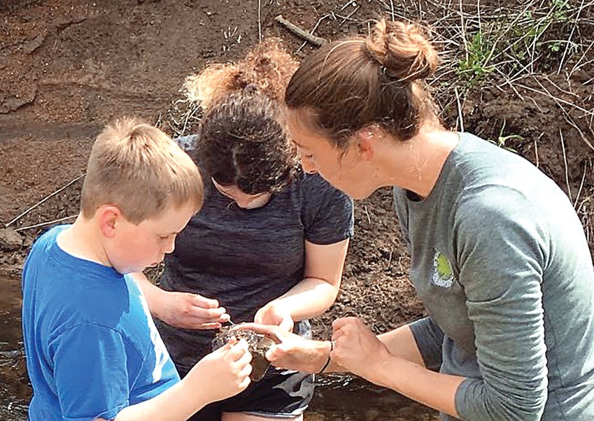 Liam Kurt, Anna Bussan and Jessica Carryer, from Jo Daviess Conservation Foundation, examine their creek finds at a meeting of the Galena Public Library&rsquo;s STEAM (science, technology, engineering, art and math) Club in May 2022. STEAM Club will meet at the library on Monday, September 12.