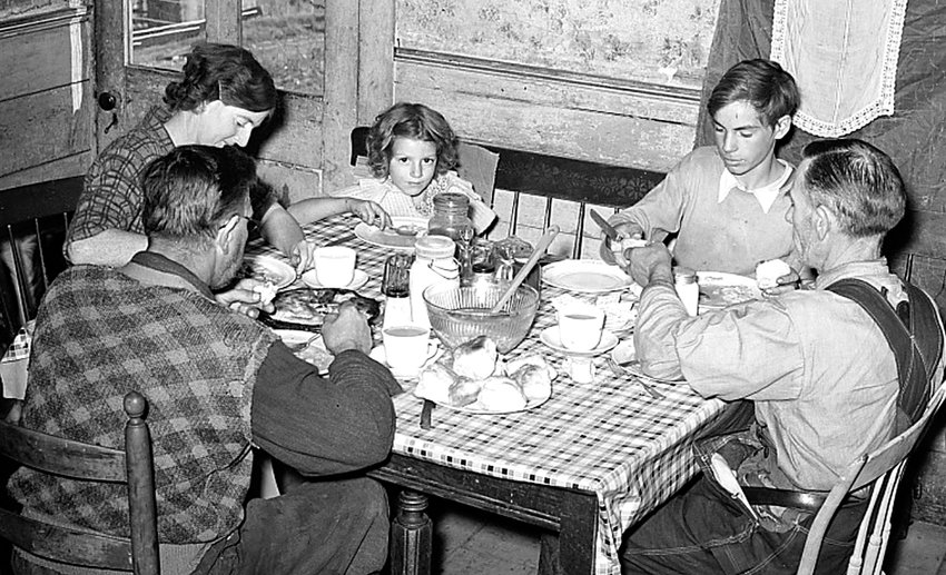 A farm family shares dinner in 1939. (Library of Congress photo archive)