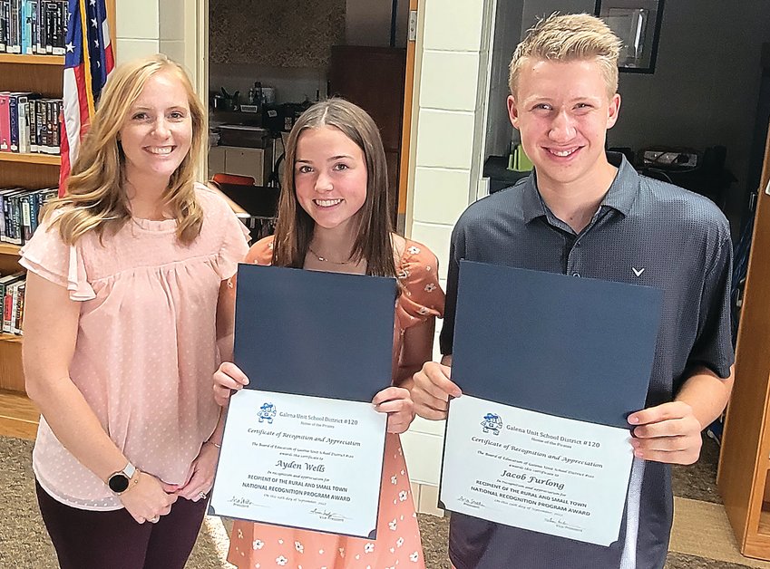 Galena School Board President Arlee Stodden stands next to Ayden Wells and Jacob Furlong, recipients of the Rural and Small Town National Recognition Program Award.