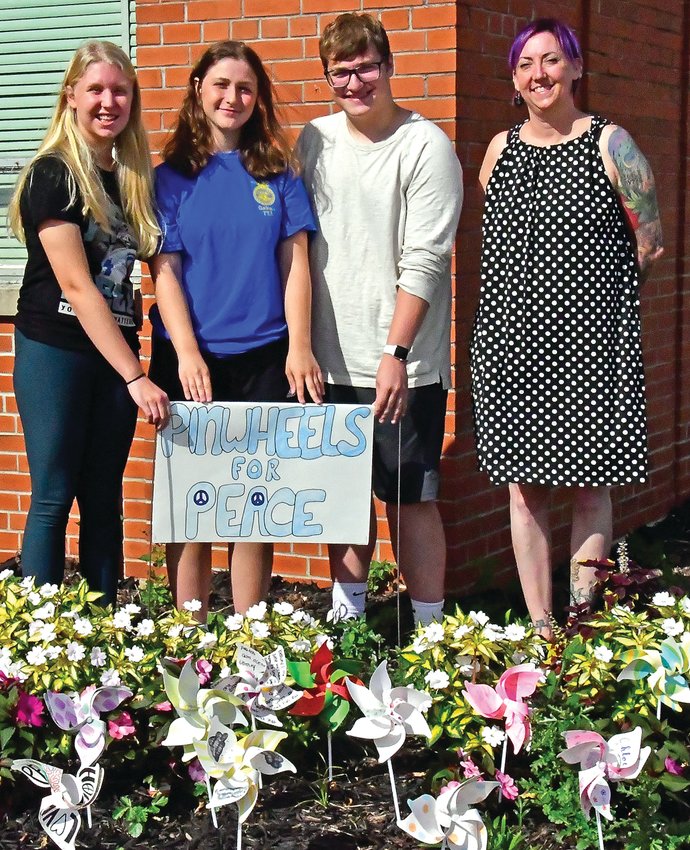 Emma Furlong, Chloe Roland, Alex Oberbroeckling and Irene Thraen-Borowski stood behind the pinwheels put up for International Peace Day.