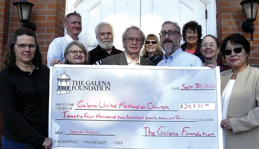 The Galena Foundation has donated $24,277.50 to the Galena United Methodist Church to assist with steeple repairs. Participating in the check passing are, back, from left, Andy Willis, Galena Foundation president; Dennis Irwin; Suzanne Sproule; Paula Schonhoff; and front, from left; Karen Greiner, Patricia Allen-Stewart, Ken Robb, Ron Leinen and the Rev. Jin-Hee Kang.