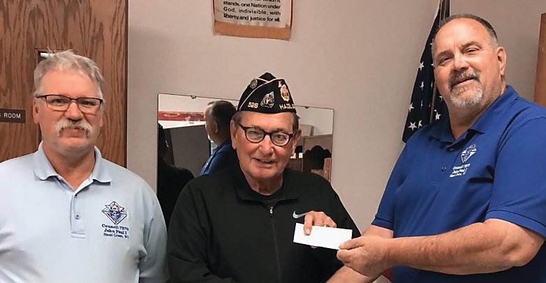 Mike Vosberg, Legion commander, receives a check from Grand Knight Chuck Frank, and event organizer, Bill Taylor.