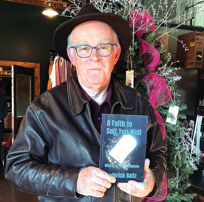 Frederick Baltz holds up his 12th book, &ldquo;A Faith to Suit You Well.&rdquo;