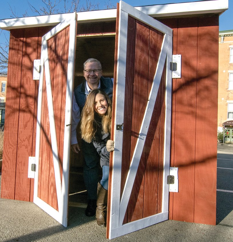 Christine Melaas and her father, Ed Bochniak, peek through the doors of a vendor booth that will be set up for the first-ever Holidaze this coming Saturday.