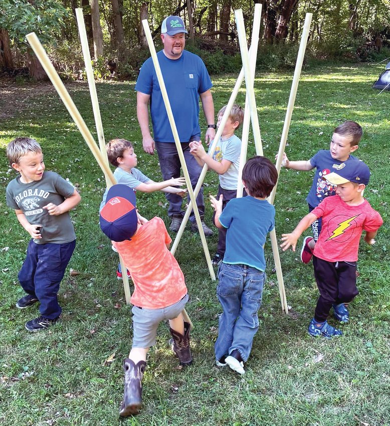 Scouts Austin Kimball, Sawyer Deitrick, William Swisher, Leo Oldenburg, Michael Peters, Kamden Hoppe and Logan Lane play Staves Game during the Pack 93 Family Camping trip while den leader Matt Oldenburg supervises.