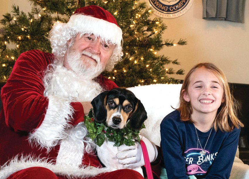 On Nov. 27, Santa visited Highway 20 Brewery in Elizabeth to take photos with his four-legged friends and their families in a Safe Haven fundraiser. Enjoying Santa&rsquo;s company are Ava Kautz, right, and her best friend, Riley.