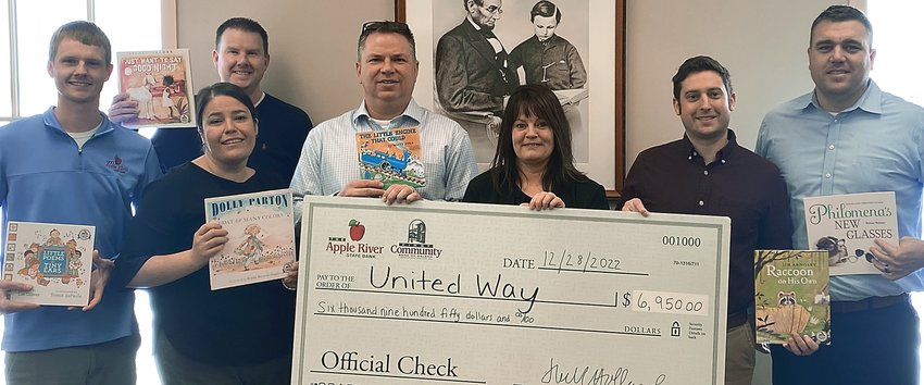 First Community Bank of Galena staff members participate in a check passing with United Way of Northwest Illinois Executive Director Connie Kraft. Participating in the check passing are, from left, Austin Gerlich, Marce Doyle, Chris Weis, David Wilmarth, Connie Kraft, Zeke Winders and Devin Patterson.