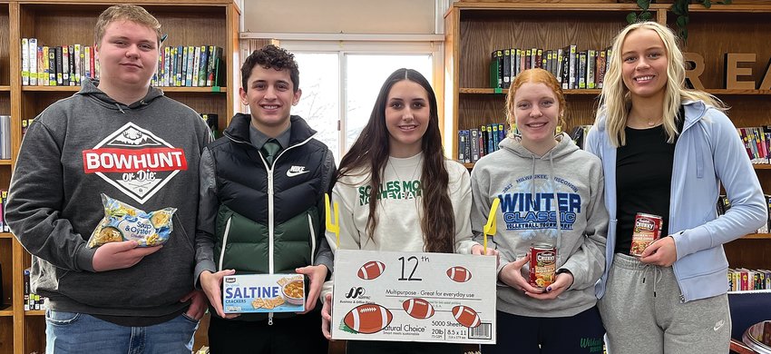 NHS members (from left) Mitchel Travis, Charlie Wiegel, Amanda Withington, Anna Wentz and Anniston Werner hold up some food that the senior class donated for the Souper Bowl.
