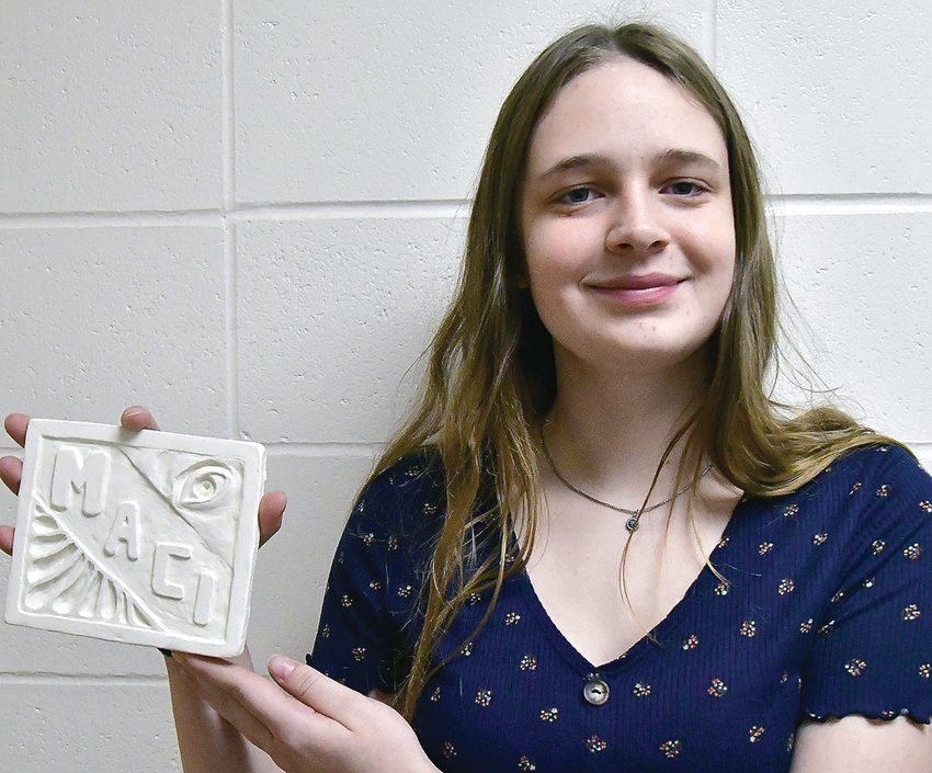 Macy Schulz is the artist of the month at Galena High School. The junior is photographed with her relief tile. The project was to include the artist&rsquo;s name and other personal touches. The tile she created depicts an eye and other designs. Schulz said, &ldquo;it was an exploratory piece because I never worked with clay before.&rdquo; Her favorite type of art to make is realistic art, with her preferred medium being a pencil. She says creating art is calming to her and she loves to use her imagination to create things that other people deem weird.